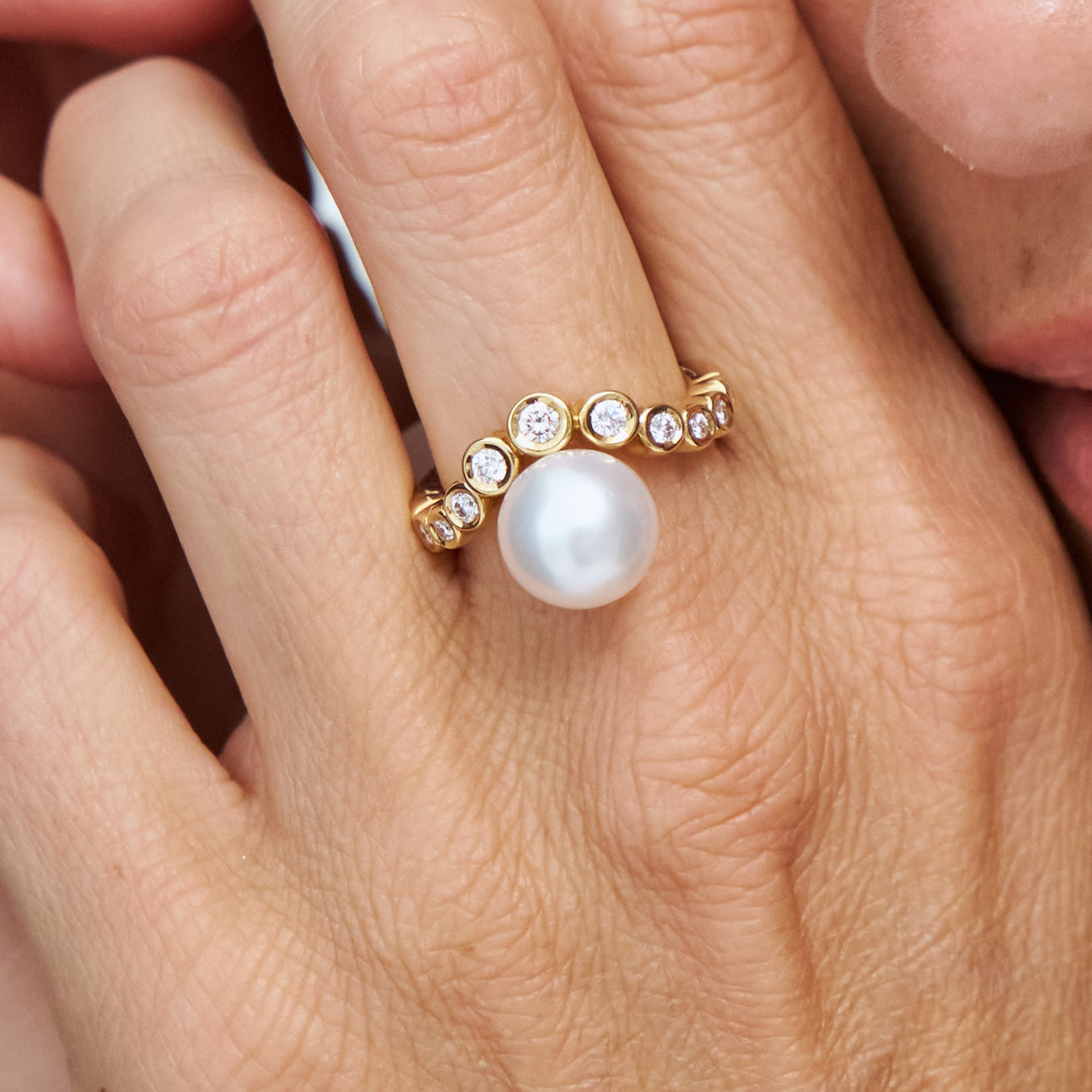 Model wearing the Autore South Sea Pearl Bezel Wave Ring in 18kt yellow gold