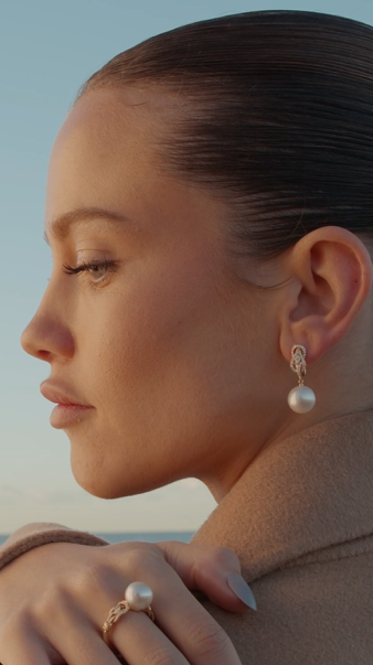 Woman wearing pearl earrings and ring with a blurred background