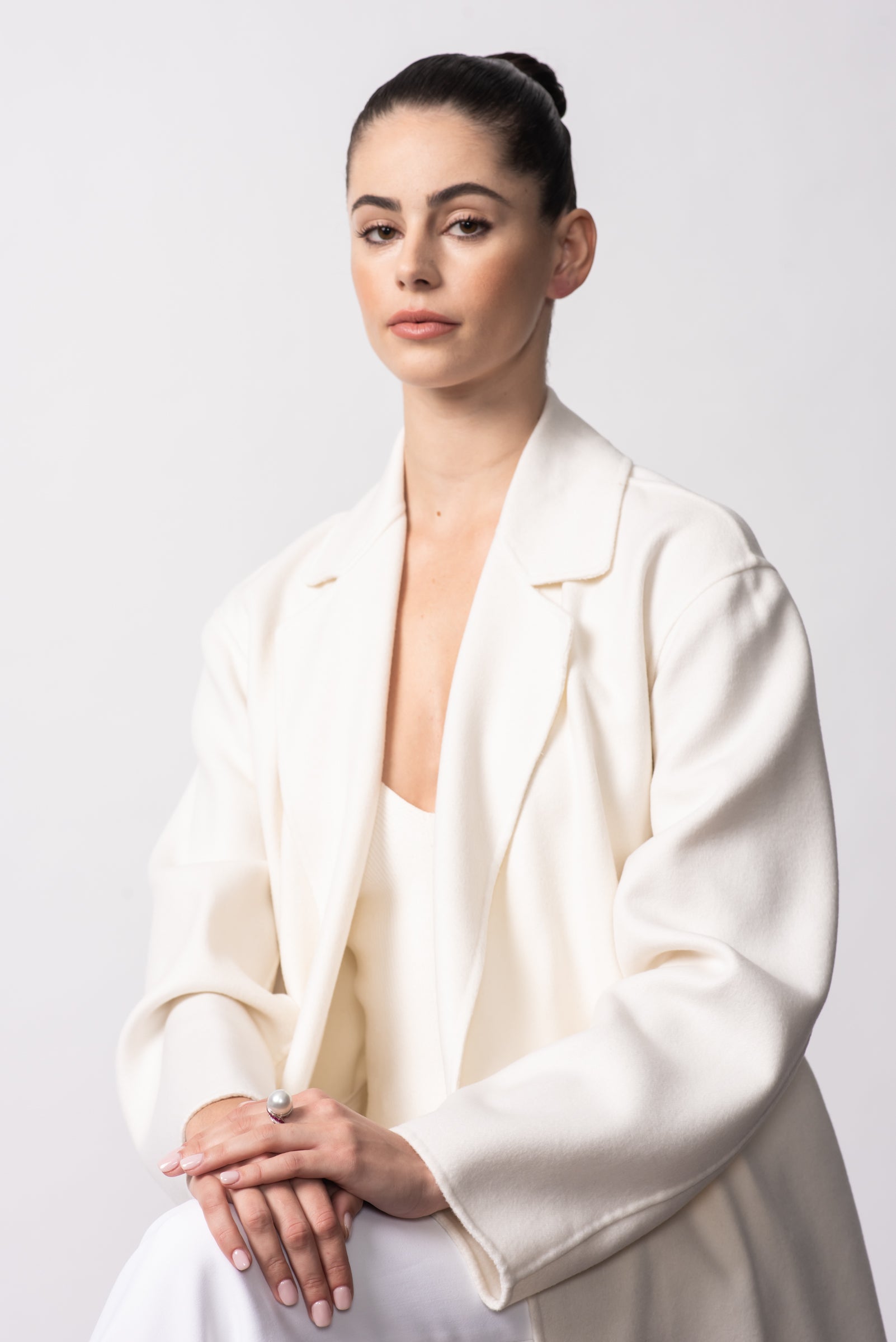 Model wearing a white blazer with the Autore South Sea pearl, ruby and diamond ring in 18kt white gold
